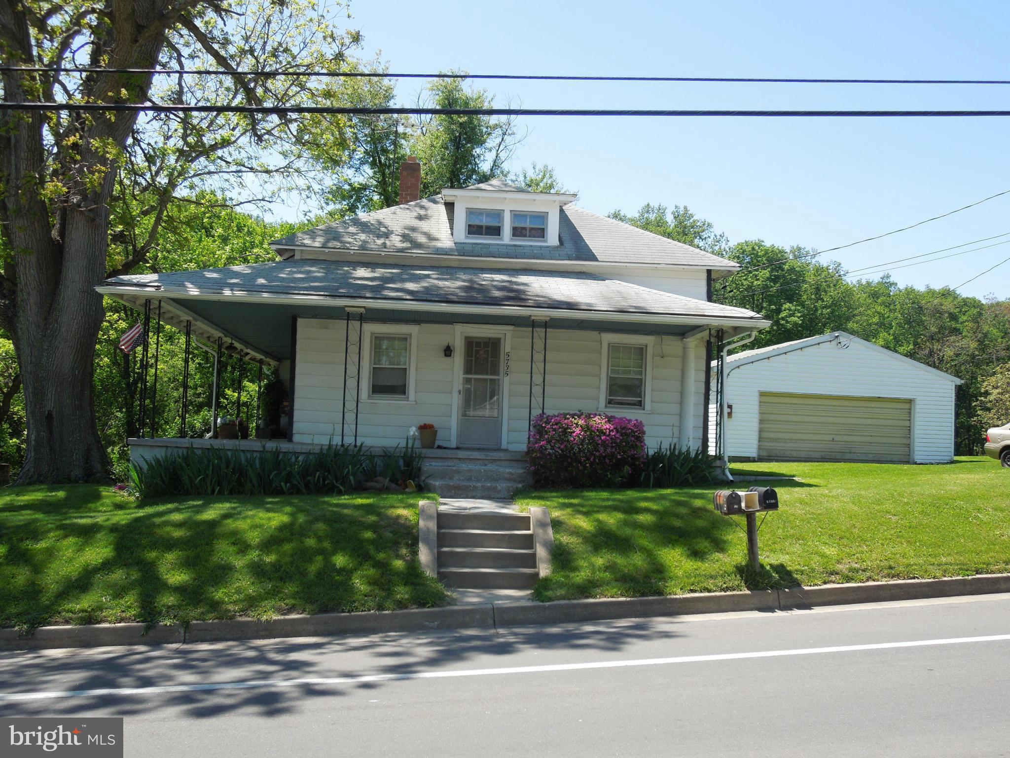 5735 Shookstown Road Frederick, MD 21702 - Photo 1 of 1 a front view of a house with a garden and trees
