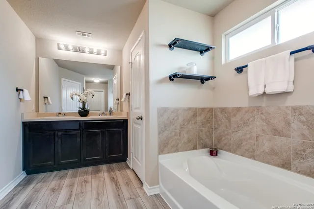 a bathroom with a bathtub sink and mirror