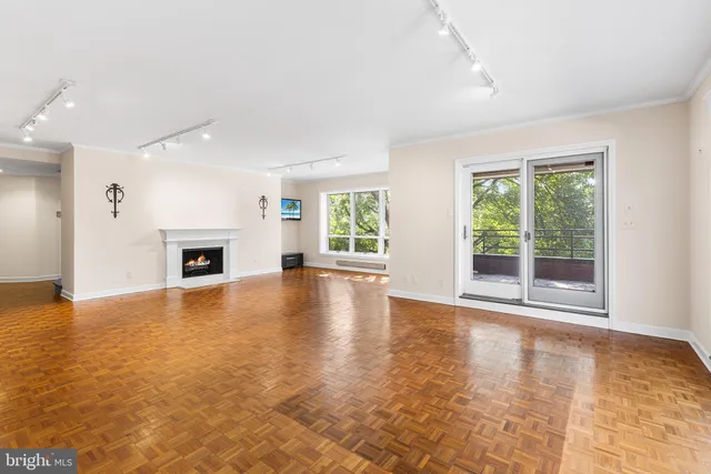 a hallway with white cabinets and wooden floor
