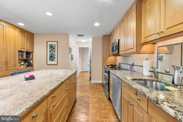 a kitchen with kitchen island a refrigerator stove microwave and cabinets