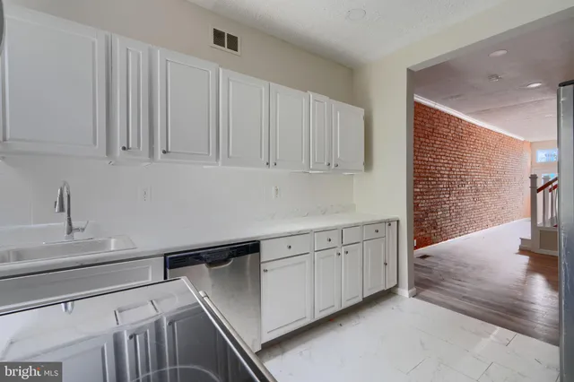 a kitchen with granite countertop white cabinets and white appliances