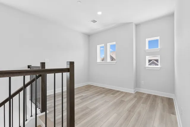 a view of a hallway with wooden floor and closet