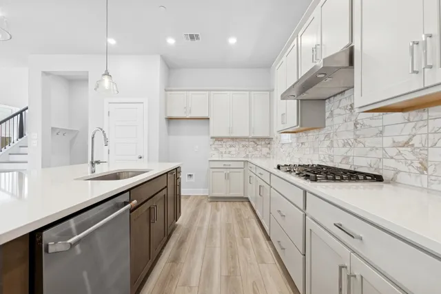 a kitchen with a sink stove top oven and cabinets