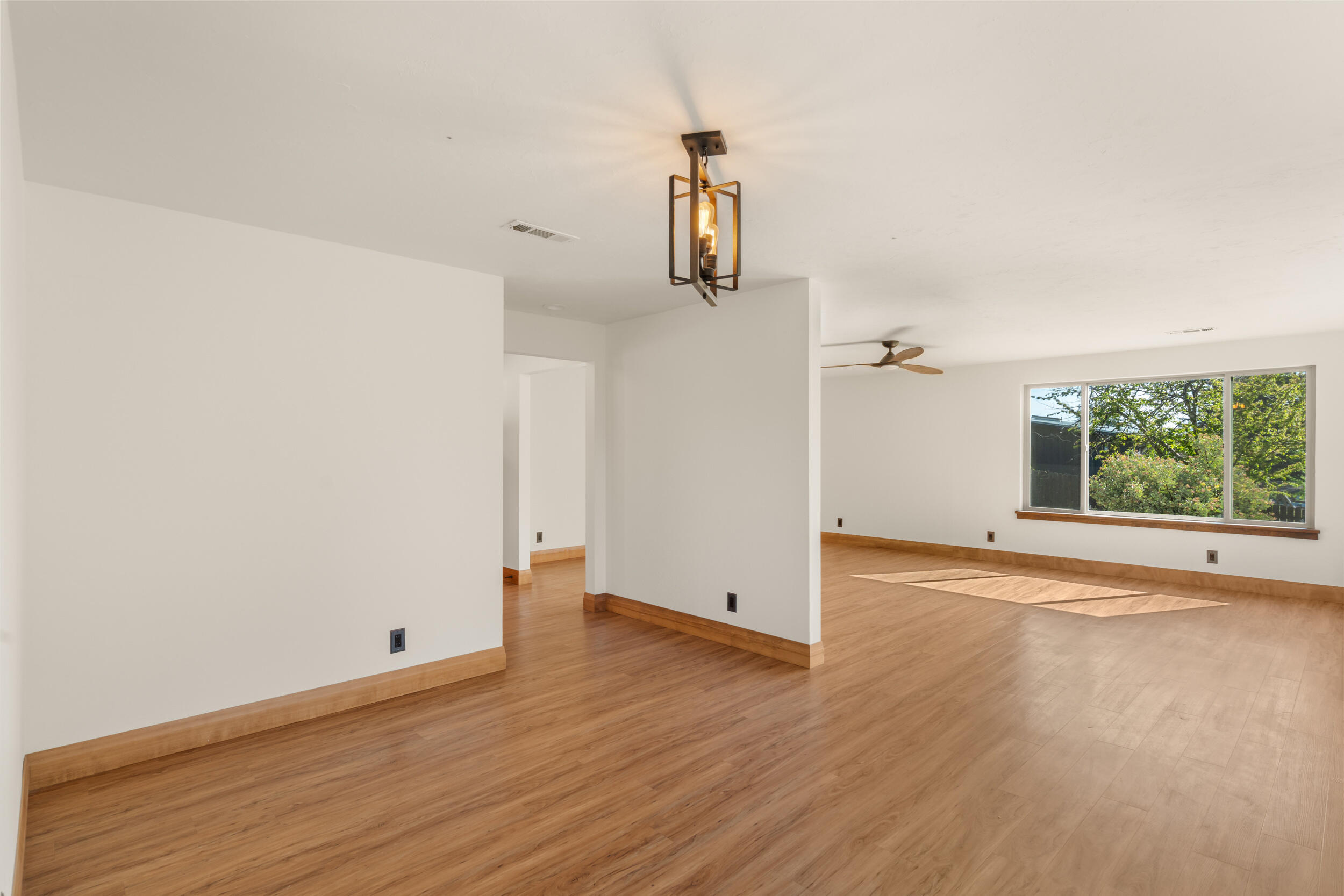 3583 Ross Lane Central Point, OR 97502 - Photo 9 of 52 an empty room with wooden floor cabinet and windows