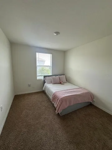 a spacious bedroom with a bed and a window