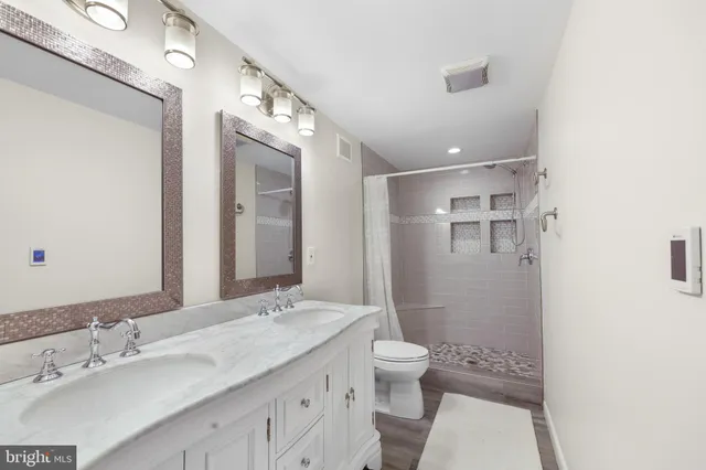 a bathroom with a sink a toilet and shower