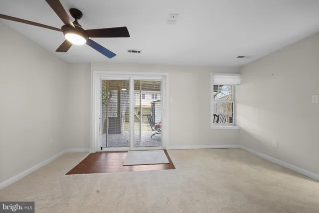 an empty room with fan and windows