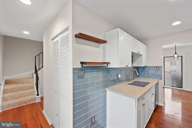 a kitchen with a sink a refrigerator and cabinets
