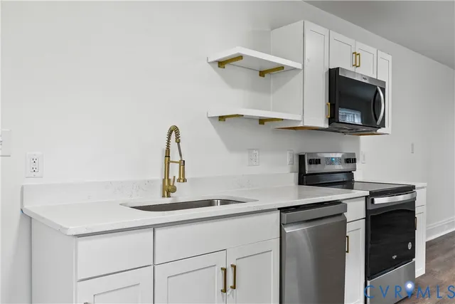 a kitchen with a sink and a stove top oven with wooden floor