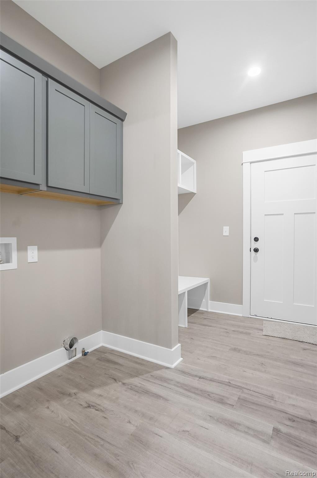9033 Copper Ridge Drive Davison, MI 48423 - Photo 12 of 29 Laundry area with light wood-type flooring, washer hookup, and cabinet space