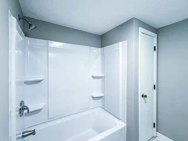 a view of an empty room with wooden floor and windows