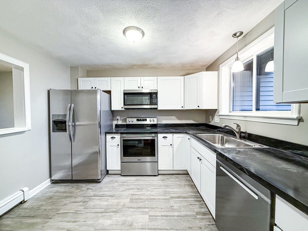 24 Wilson Street, Unit 4 Marlborough, MA 01752 - Photo 3 of 29 a kitchen with a sink stove and refrigerator