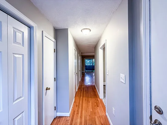 a view of a hallway with wooden floor and closet