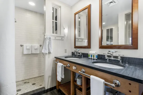 a bathroom with a granite countertop sink a mirror and shower