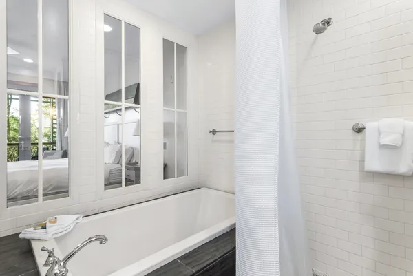 a bathroom with a tub a sink and a window
