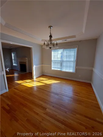 a view of a livingroom with wooden floor and a ceiling fan