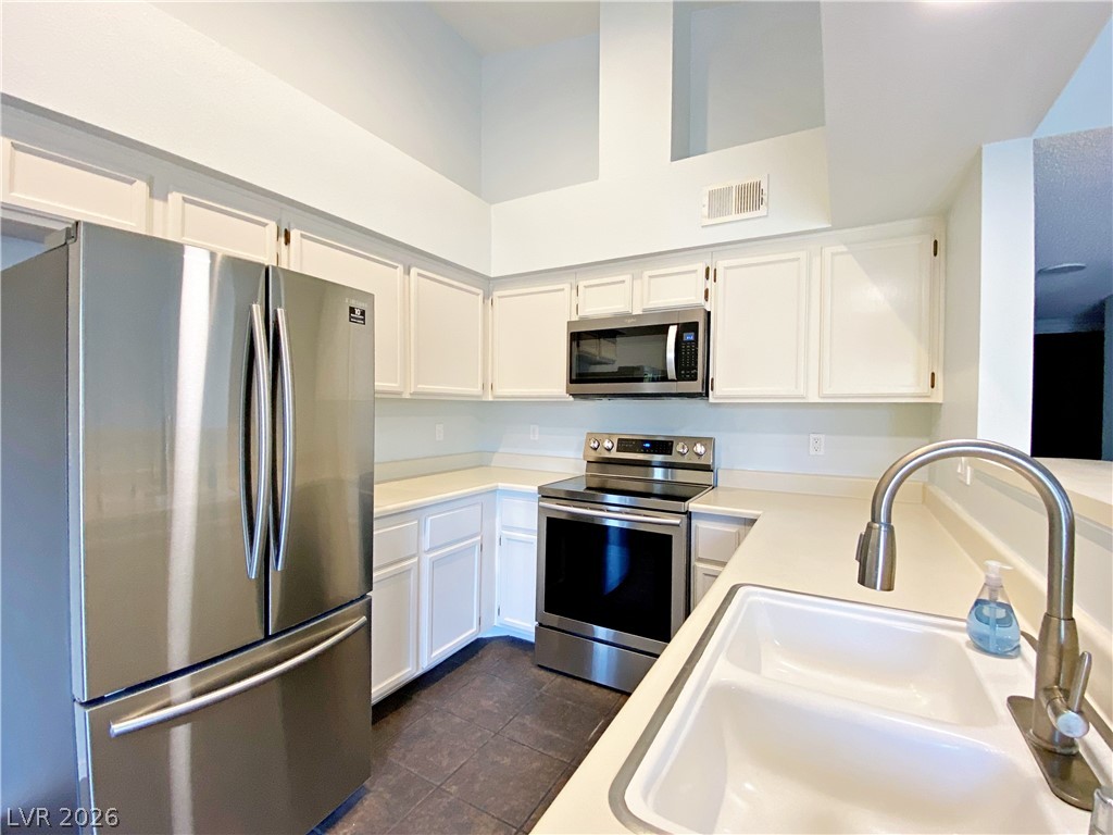 A well-appointed kitchen features stainless steel appliances and abundant white cabinetry, ready for culinary endeavors.