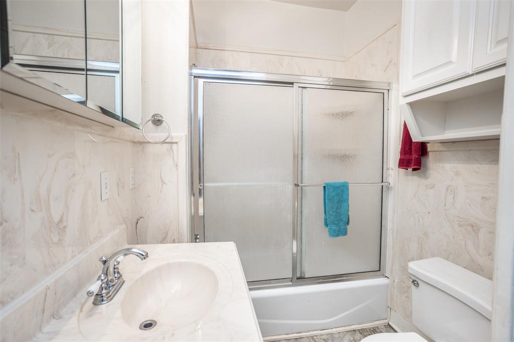 206 Ritchey Street Gainesville, TX 76240 - Photo 24 of 36 a bathroom with a sink and shower