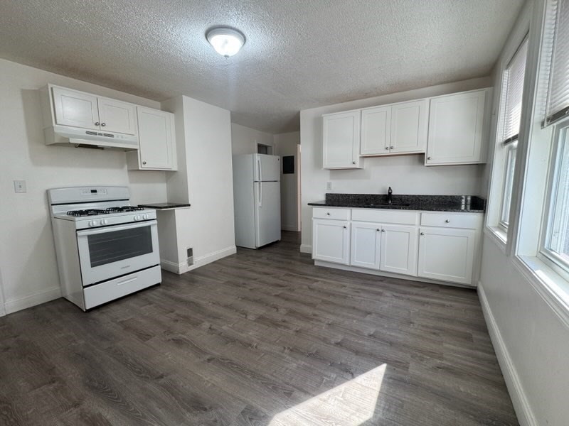 176 Ferry Street, Unit 3L Everett, MA 02149 - Photo 3 of 13 a kitchen with stainless steel appliances granite countertop a stove a sink and a refrigerator