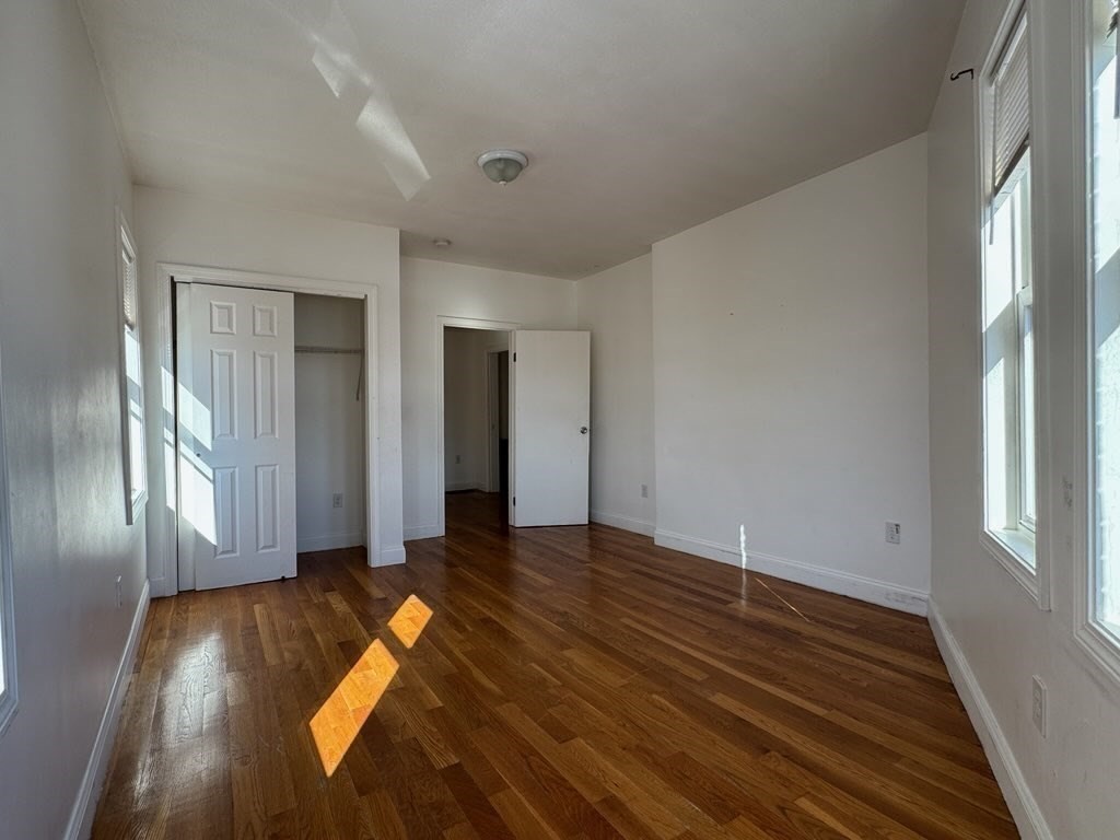 176 Ferry Street, Unit 3L Everett, MA 02149 - Photo 6 of 13 a view of empty room with wooden floor and fan