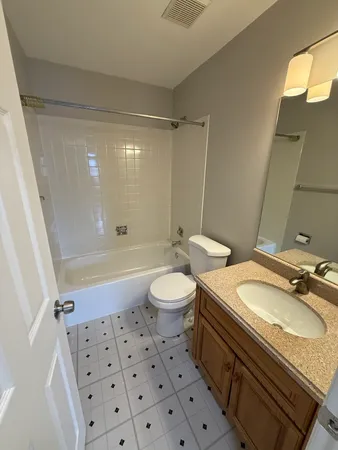 a bathroom with a granite countertop sink toilet a mirror and shower
