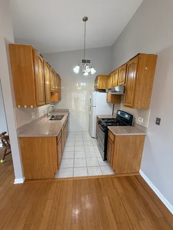 a kitchen with stainless steel appliances granite countertop wooden floors a stove and a sink