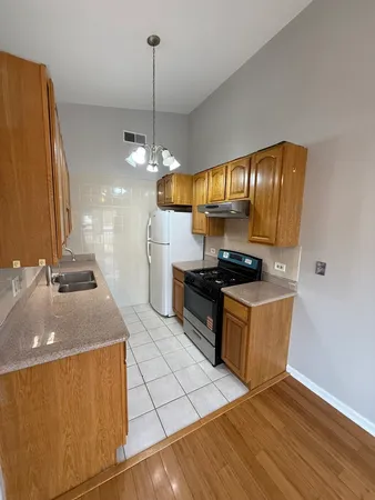 a kitchen with stainless steel appliances granite countertop a sink a stove and a wooden floors