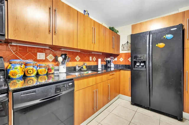 a kitchen with stainless steel appliances granite countertop a refrigerator and a sink