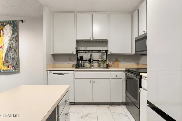 a kitchen with a stove top oven sink and cabinets