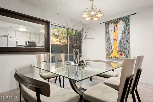 a dining room with furniture a chandelier and window