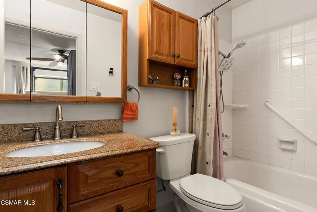 a bathroom with a granite countertop sink toilet and shower
