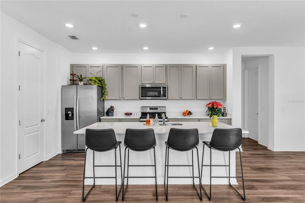 5816 Bar Ranch Road St. Cloud, FL 34771 - Photo 20 of 43 a kitchen with stainless steel appliances kitchen island granite countertop a dining table chairs and refrigerator