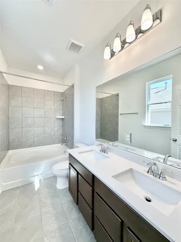 a bathroom with a tub double sink and mirror