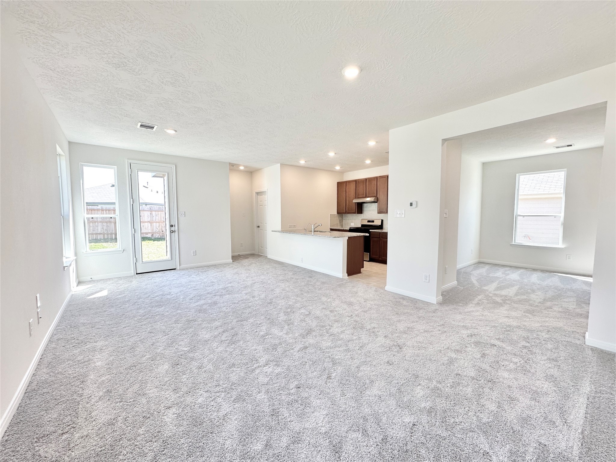 562 Broken Boulder Street Magnolia, TX 77355 - Photo 3 of 16 a view of a livingroom with a kitchen and a refrigerator