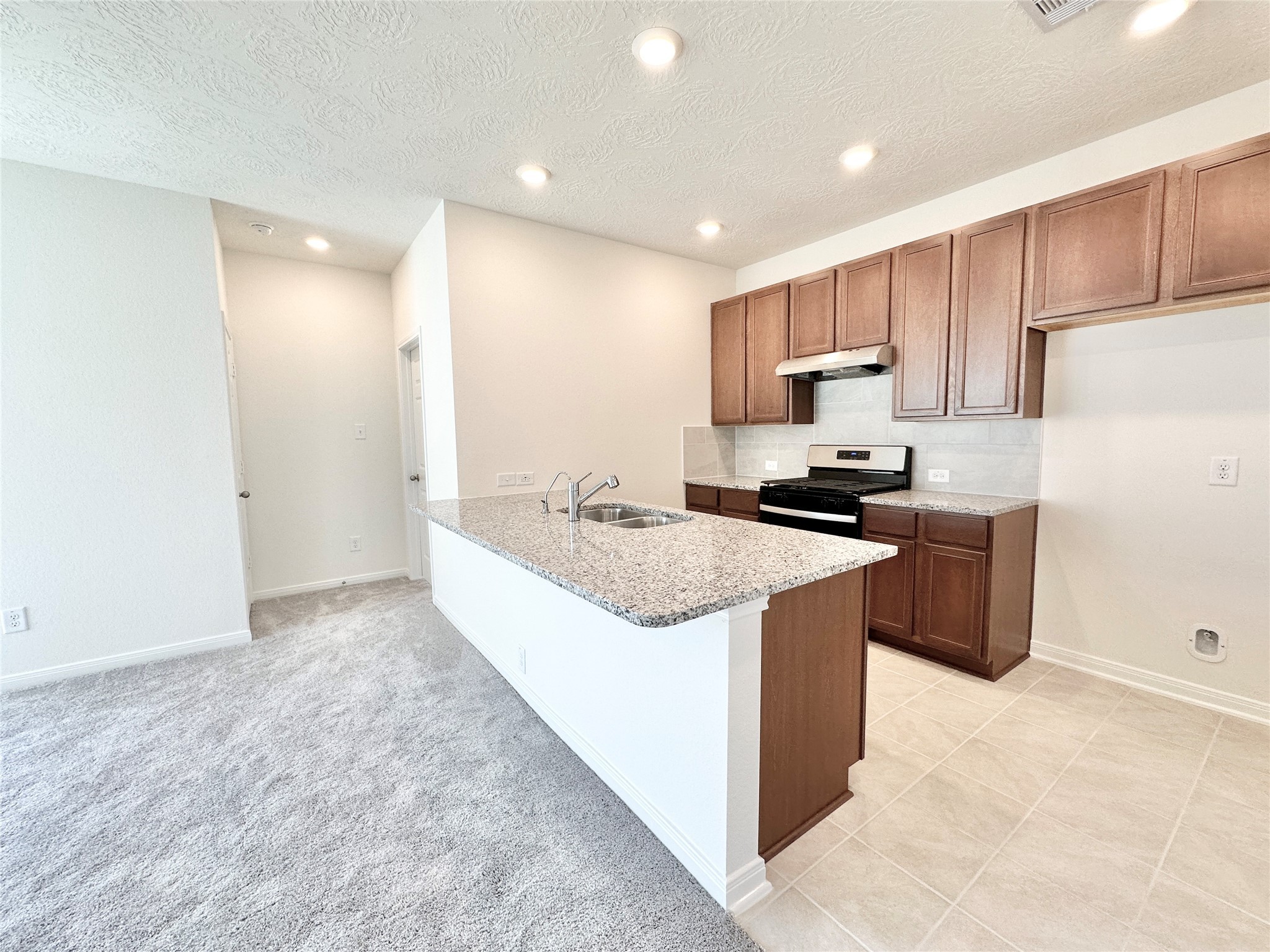 562 Broken Boulder Street Magnolia, TX 77355 - Photo 6 of 16 a kitchen with a sink a stove a refrigerator and a refrigerator