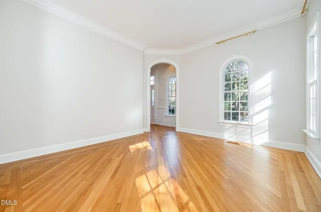 a view of a big room with windows and chandelier fan