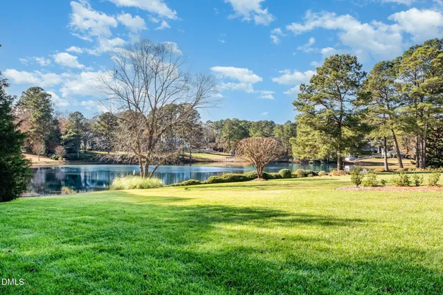 a view of a livingroom with a chandelier wooden floor and windows