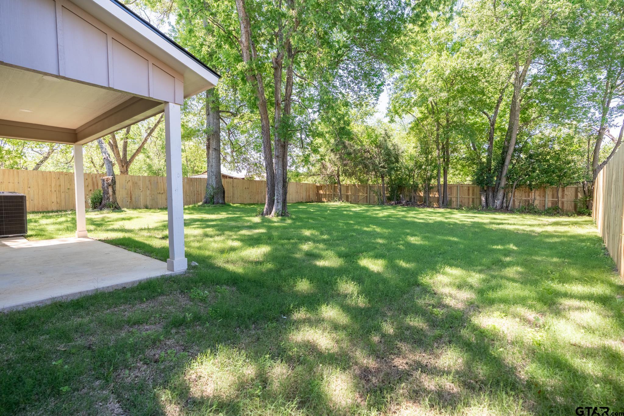 233 Harrison Street Longview, TX 75601 - Photo 36 of 44 a view of a house with a backyard and a tree