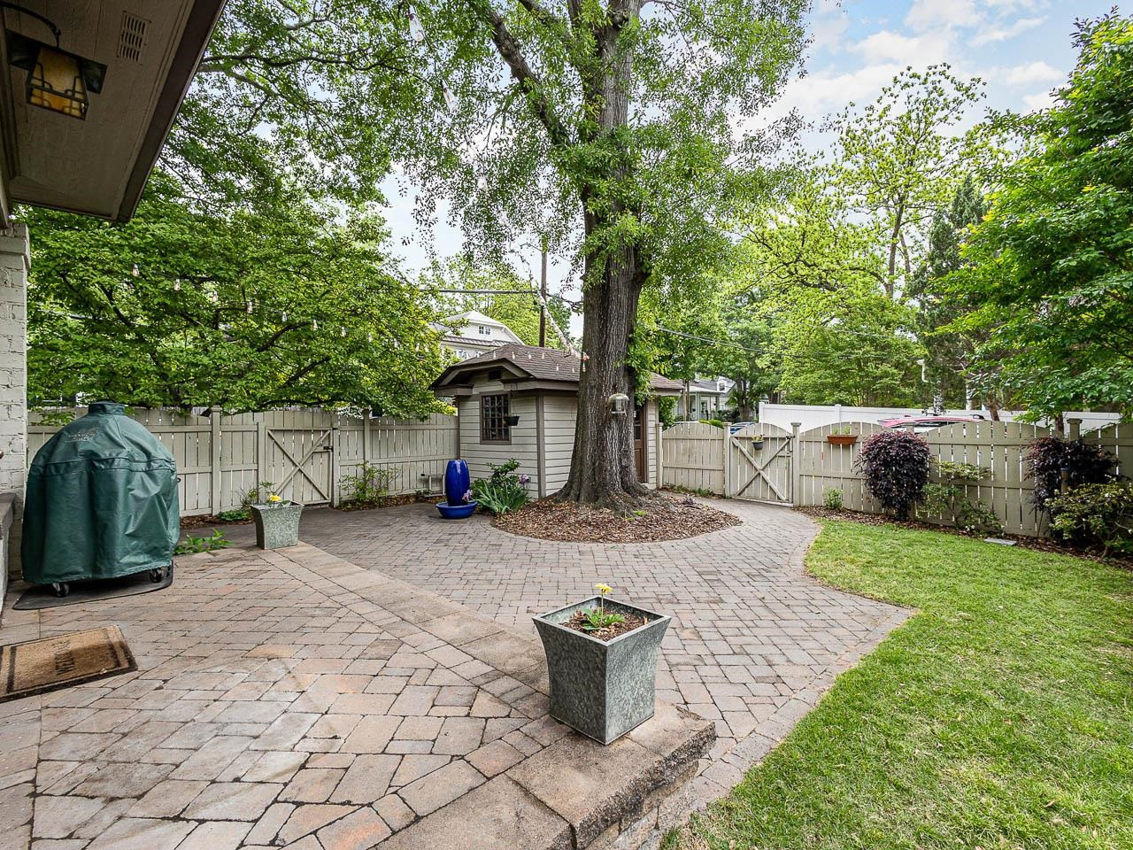 401 West Whitaker Mill Road Raleigh, NC 27608 - Photo 7 of 30 Tastefully landscaped back yard that invites you to sit and enjoy the shade all summer long. Fenced in with a patio, grassy area, raised flower bed and storage shed. Back yard