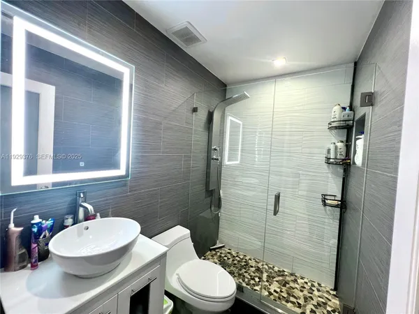 a bathroom with a sink a toilet and shower