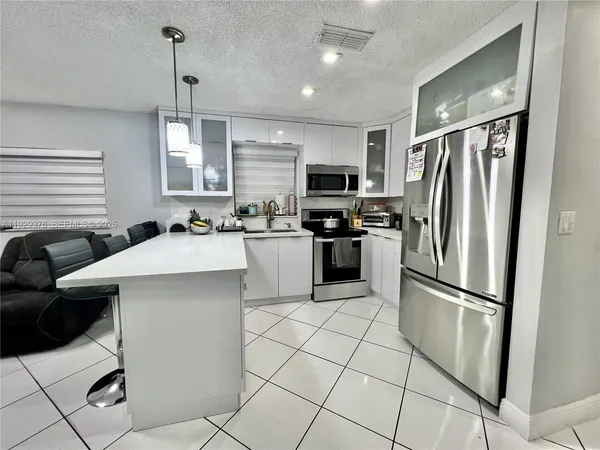 a kitchen with stainless steel appliances a refrigerator sink and microwave