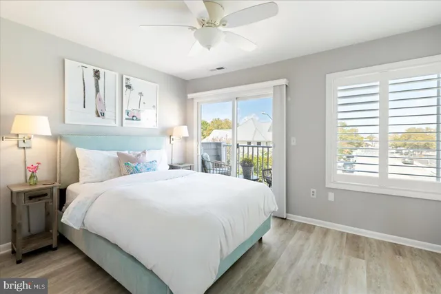 a bedroom with a bed a flat tv screen and a large window