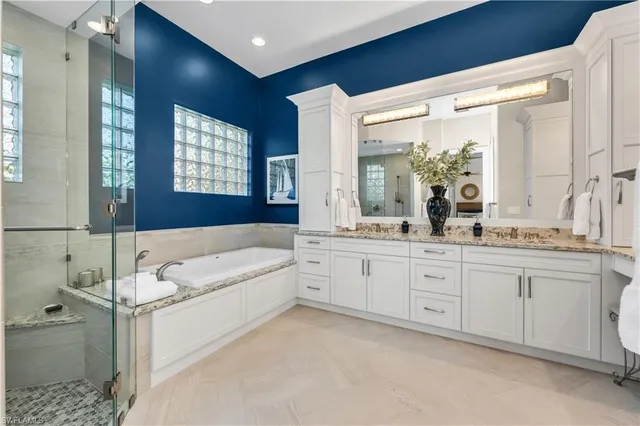 a spacious bathroom with a double vanity sink a mirror and a bathtub