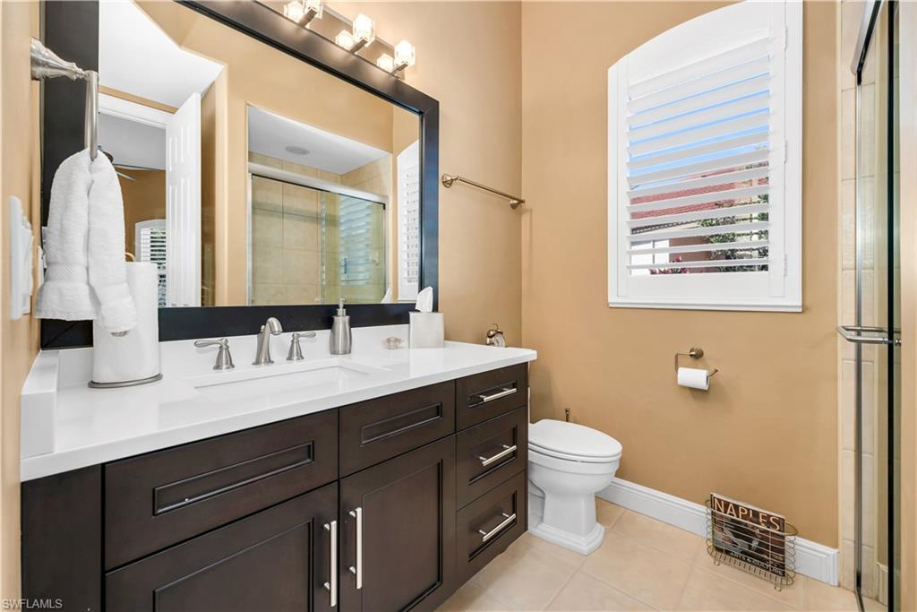 1033 Tierra Lago Way Naples, FL 34119 - Photo 19 of 27 a bathroom with a double vanity sink toilet and a mirror