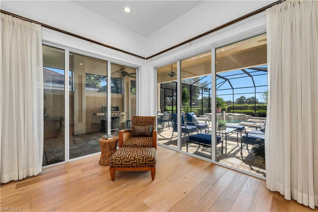 1033 Tierra Lago Way Naples, FL 34119 - Photo 5 of 27 a living room filled with furniture and a wooden floor