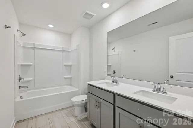 a bathroom with a granite countertop sink a toilet a bathtub and shower