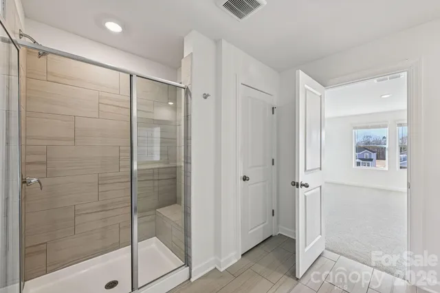 a bathroom with a shower and a glass door