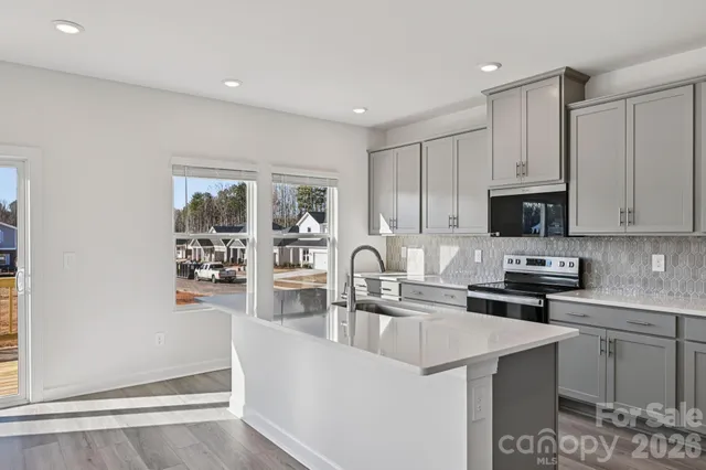 a kitchen with stainless steel appliances granite countertop a stove a sink and a refrigerator