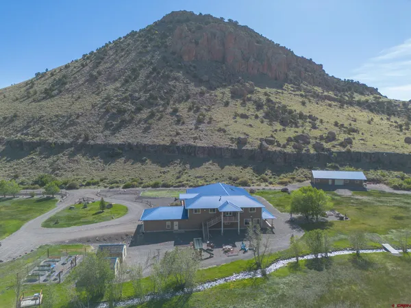 a backyard of a house with a yard and mountain view in back