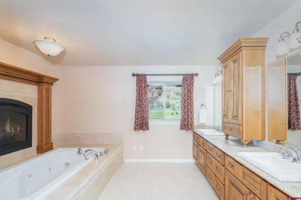 a spacious bathroom with a tub sink and mirror